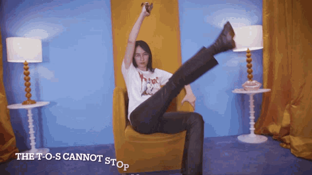 a woman is sitting in a chair with her leg up and the words " the t-o-s cannot stop " below her