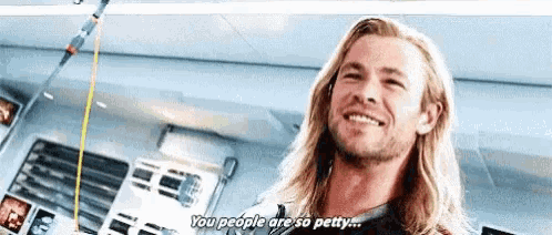 a man with long blonde hair and a beard is smiling and saying `` you people are so petty . ''