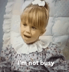 a little girl is sitting in a chair with a bow in her hair and says `` i 'm not busy '' .