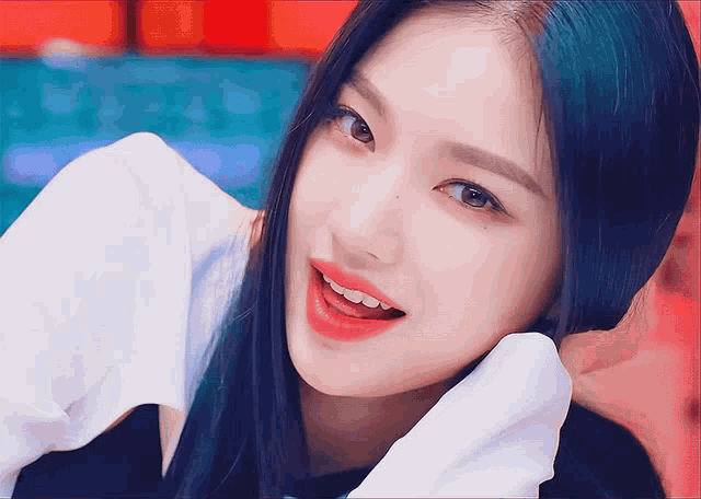 a woman with blue hair and red lips is smiling