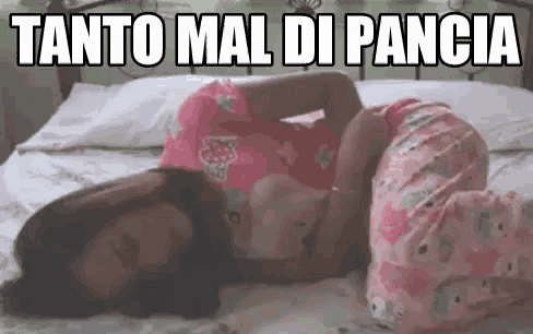 a woman is laying on a bed with her legs crossed and holding her belly .