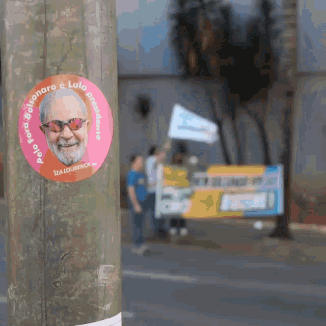 a sticker on a pole says bolsonaro & lula