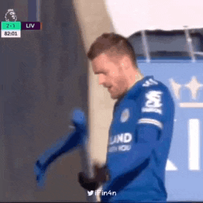 a soccer player in a blue jersey is standing in front of a stadium .