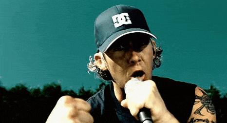a man singing into a microphone wearing a hat with the letter d on it