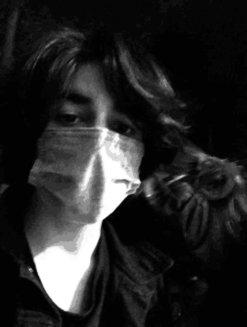 a black and white photo of a person with a mask on their face