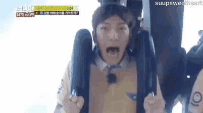 a man is screaming while riding a slingshot ride .