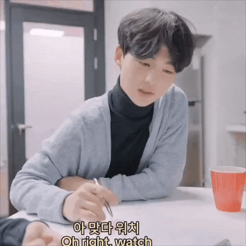 a young man sits at a table with a cup of coffee and the words oh right watch above him