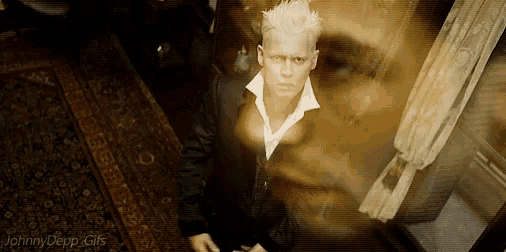 a man in a suit and white collared shirt is standing in a room with a ghost behind him .