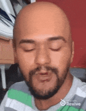 a man with a beard and a bald head is making a funny face .