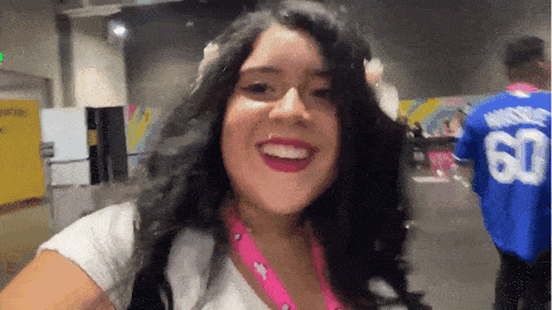 a woman wearing a white shirt with the number 60 on it smiles