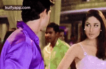 a man and a woman are standing next to each other in a room .