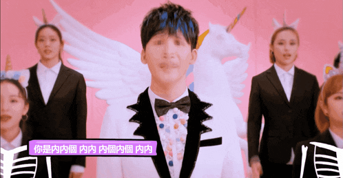 a man in a tuxedo stands in front of a group of women wearing unicorn ears
