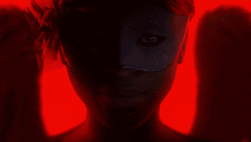 a close up of a person 's face with glowing eyes and a red background