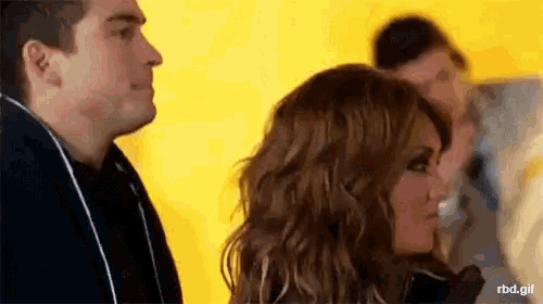 a man and a woman are standing next to each other and looking at each other .