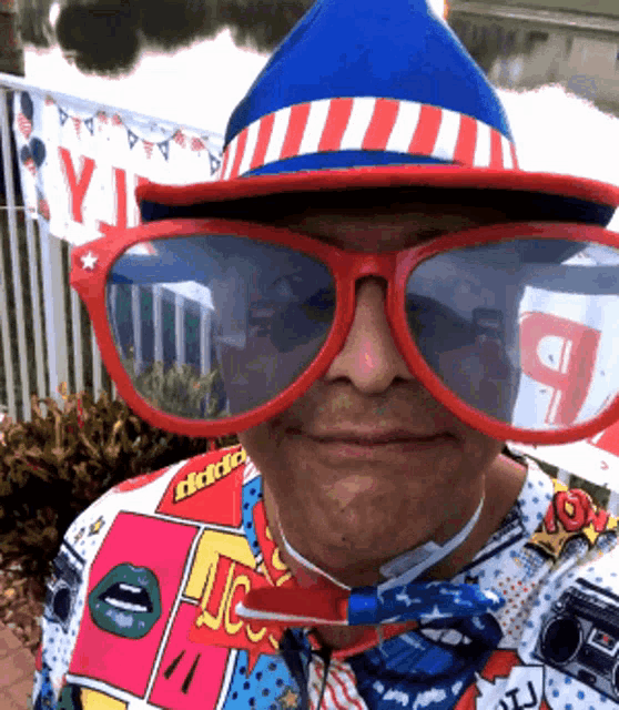 a man wearing a red white and blue hat and sunglasses has a shirt that says daddy on it