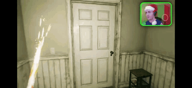 a man in a santa hat is standing in front of a door in a room .