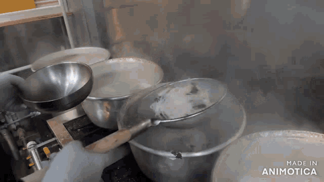 a person is pouring something into a pot with the words made in animotica at the bottom