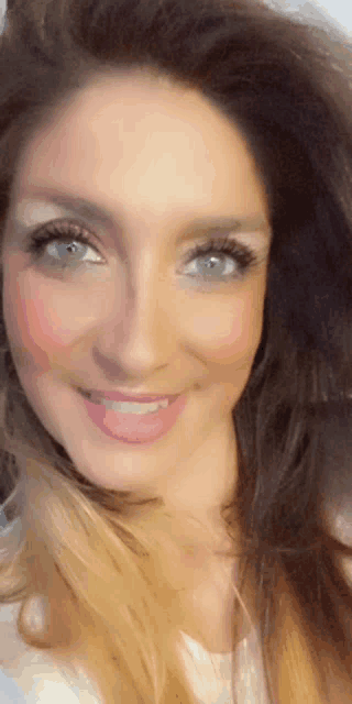 a close up of a woman 's face with a white shirt on