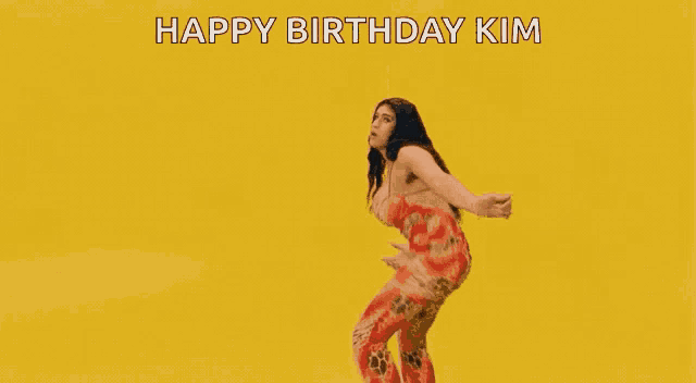 a woman in a bikini is standing in front of a yellow background and says `` happy birthday kim '' .