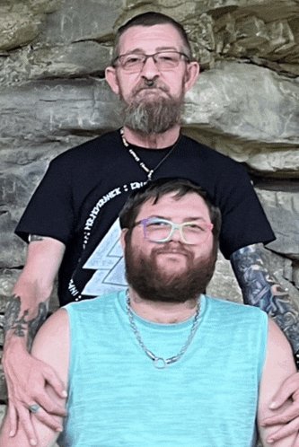 two men are posing for a picture and one has a lanyard around his neck that says " evidence "