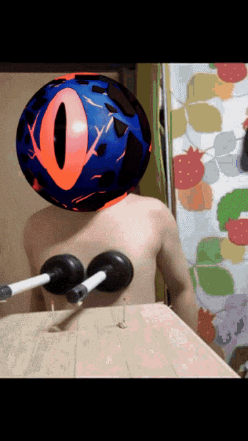 a person without a shirt has a blue ball on their head with an orange eye