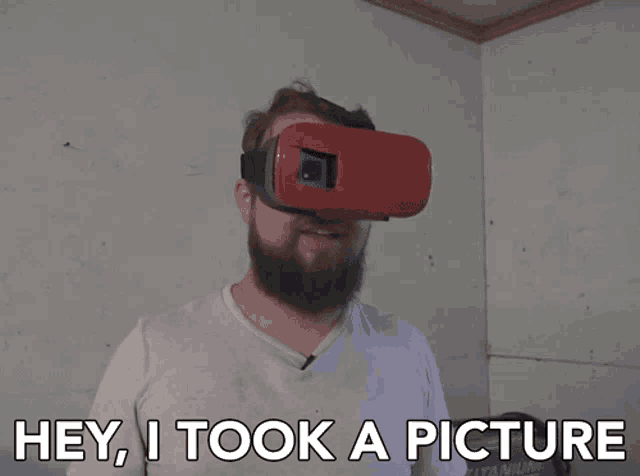 a man wearing a virtual reality headset with the words hey i took a picture below him