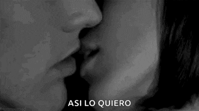 a man and a woman are kissing in a black and white photo with the words `` asi lo quiero '' written below them .