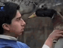 a man holding a duck in front of a screen that says good morning