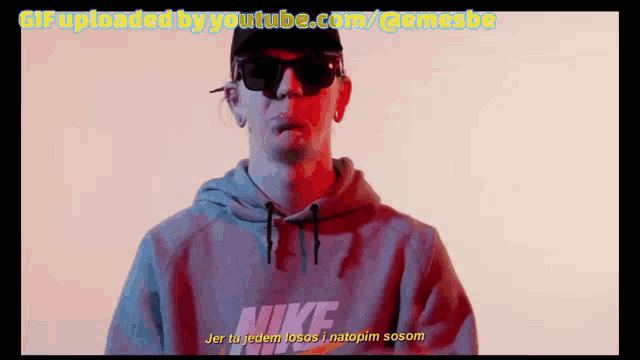 a man wearing sunglasses and a nike sweatshirt says jer tu jeden locos i natopim sosom