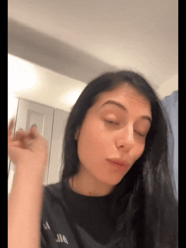 a woman with her eyes closed wearing a black shirt
