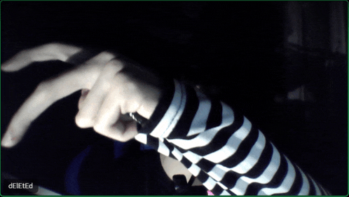 a person wearing a black and white striped shirt has their finger pointing to the right