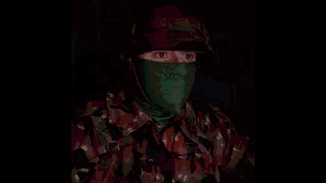 a soldier wearing a mask and a helmet looks at something in the dark