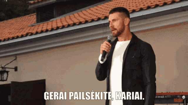a man speaking into a microphone with the words gerai pailsekite kariai written below him