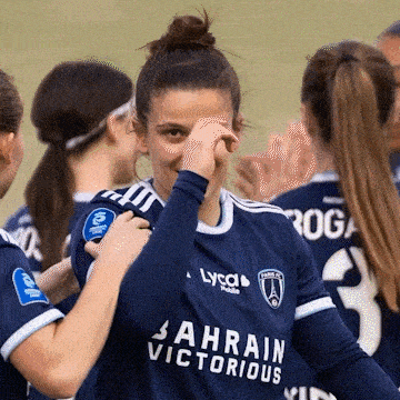 a woman wearing a jersey that says bahrain victorious covering her face