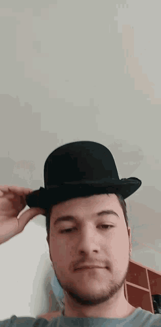 a man with a beard wearing a black top hat