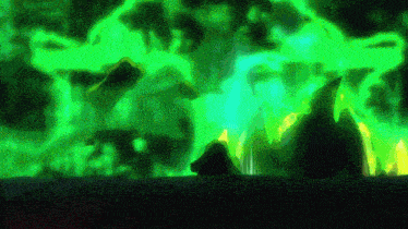 a person is standing in front of a green glowing explosion .