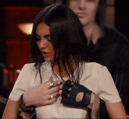 a man is holding a woman 's breast while wearing gloves