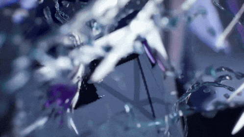 a close up of a purple and white object with water splashing around