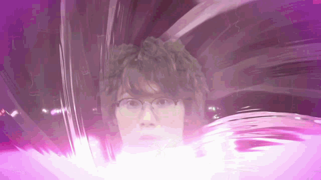 a man wearing glasses is surrounded by purple light