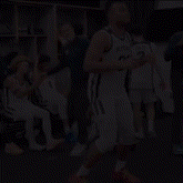 a basketball player wearing a butler jersey stands in a locker room