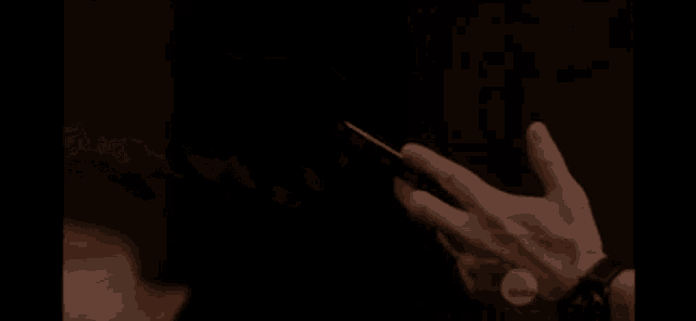 a man is holding a gun in his hand and another man is holding a lighter in his hand .