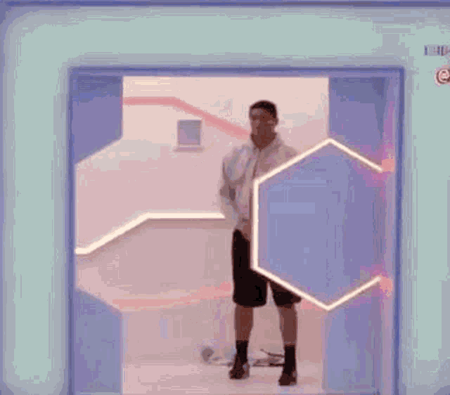 a man is standing in a doorway in a room with a blue wall .