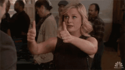 a woman is giving two thumbs up in a crowded room .