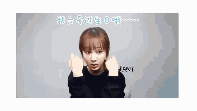 a girl making a heart with her hands in front of a white background with chinese writing on it