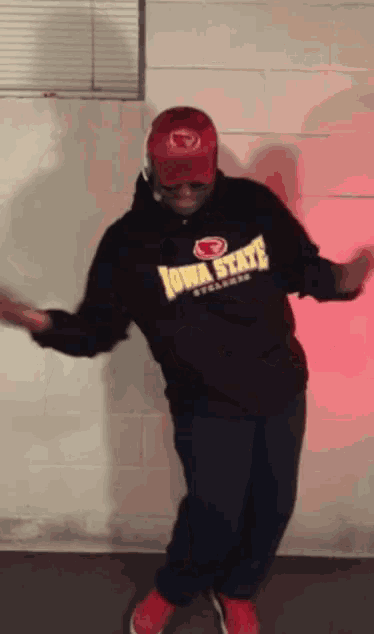 a man wearing a black iowa state sweatshirt is dancing