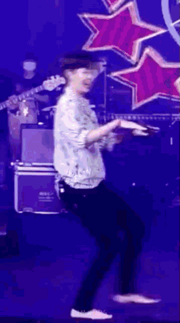 a man is dancing on a stage in front of a band