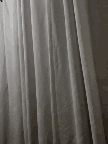 a close up of a white curtain with a black hole in it