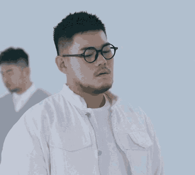 a man wearing glasses and a white jacket