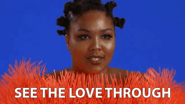 a woman with dreadlocks is surrounded by orange feathers and says see the love through