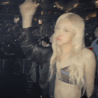 a woman in a crop top is standing in front of a crowd